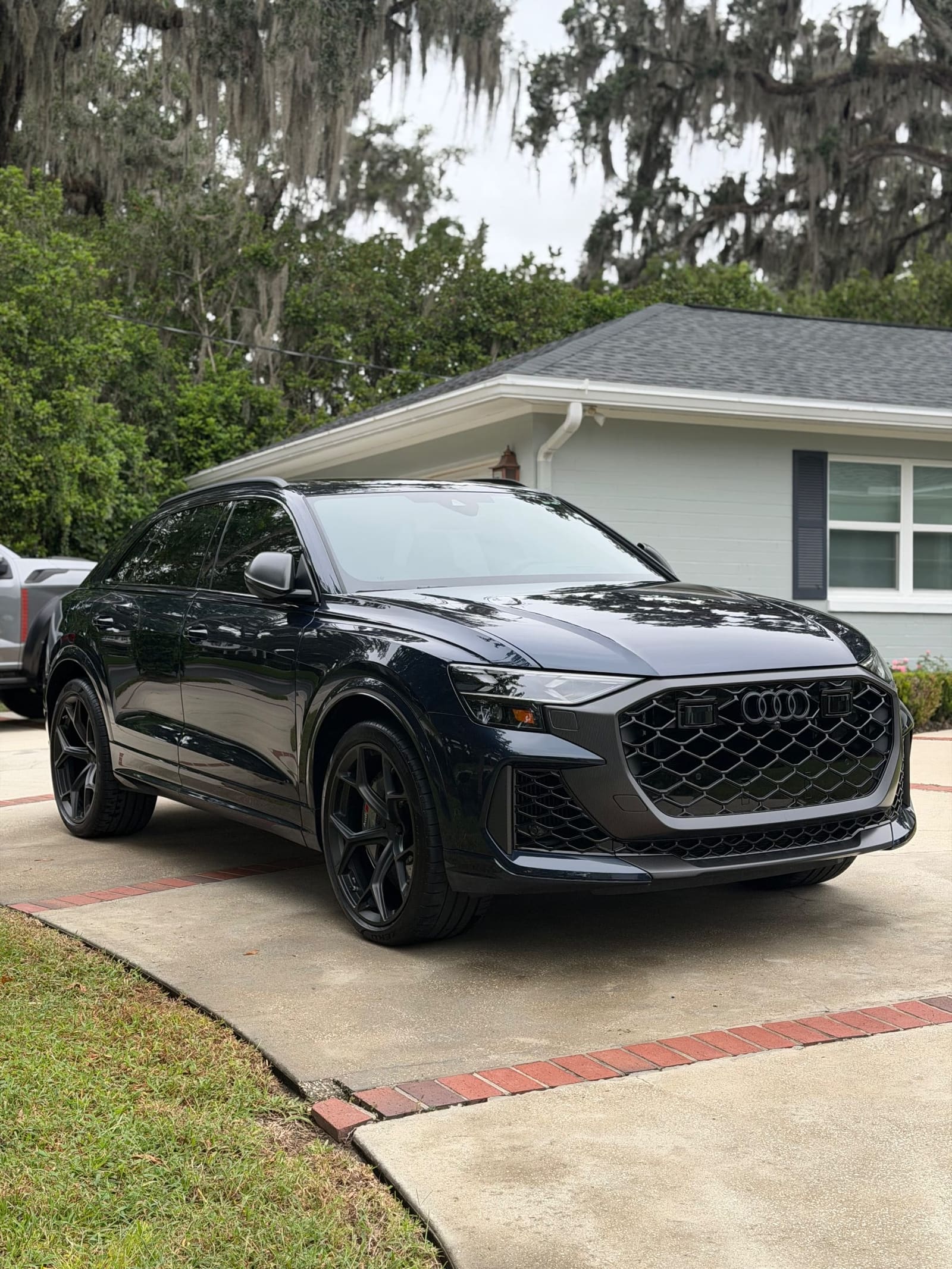 Dark SUV on a residential driveway, front three-quarter view